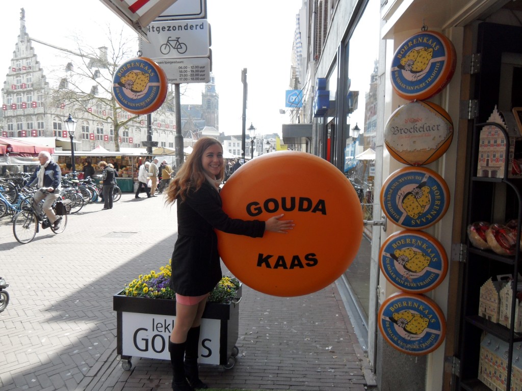 Gouda town in the Netherlands. Woman hugging a cheese.