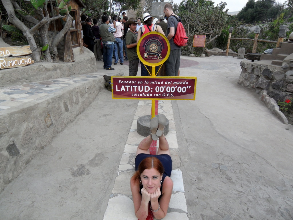 A woman lying down on the equator line while posing for a picture at the Equator Museum which is a top thing to do in Ecuador