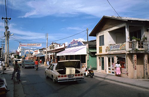 Vibrant street life in downtown San Andres Island, with colorful storefronts, local businesses, and pedestrians, reflecting the island's rich culture and bustling daily life, essential for a comprehensive travel guide.