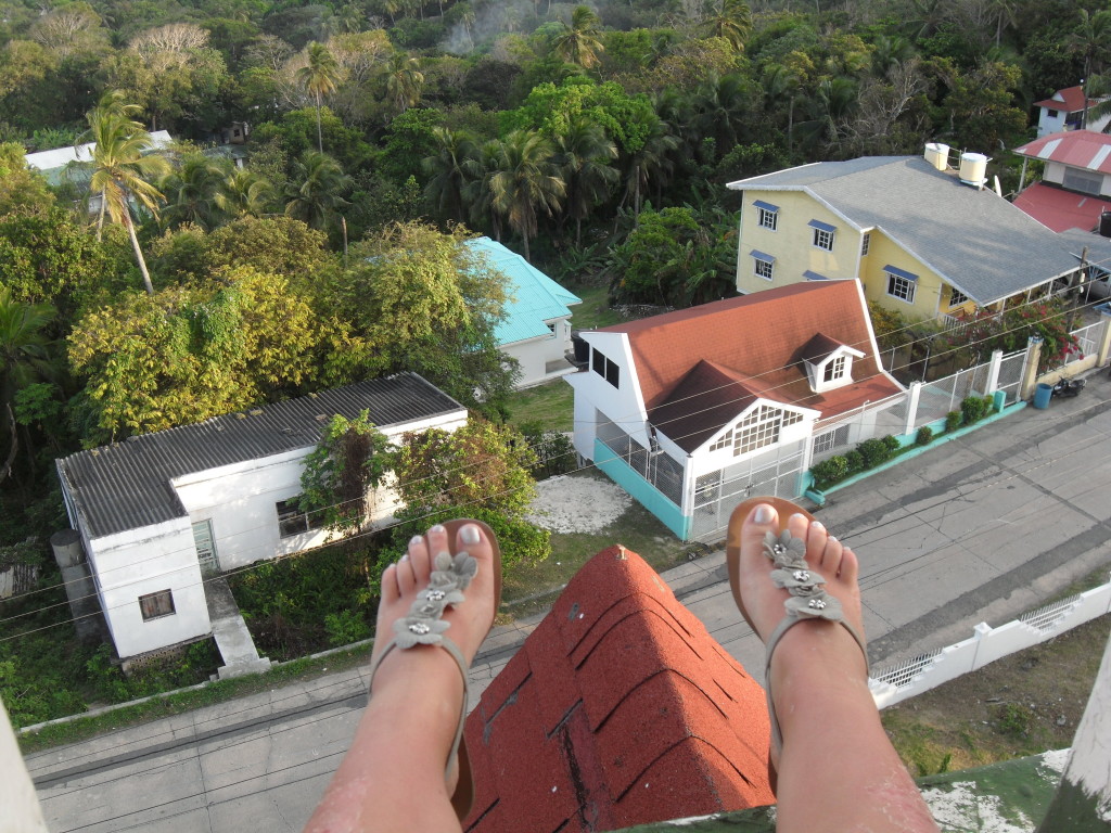 A traveler's feet dangling over the edge of the church's rooftop on San Andres Island, capturing the thrill of exploration and the laid-back island lifestyle from a personal perspective.