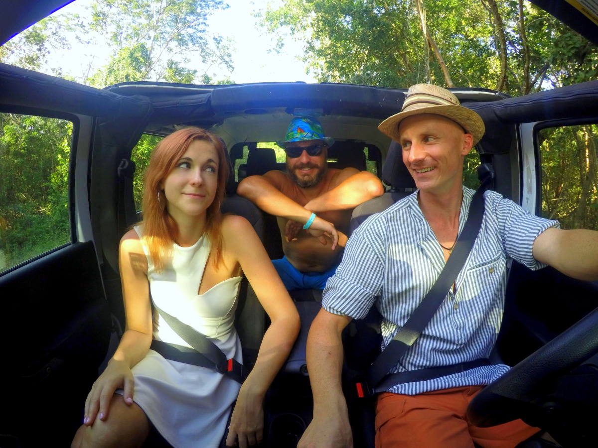 Trio of tourists enjoying their jeep rental as they explore a forested area in Mexico.
