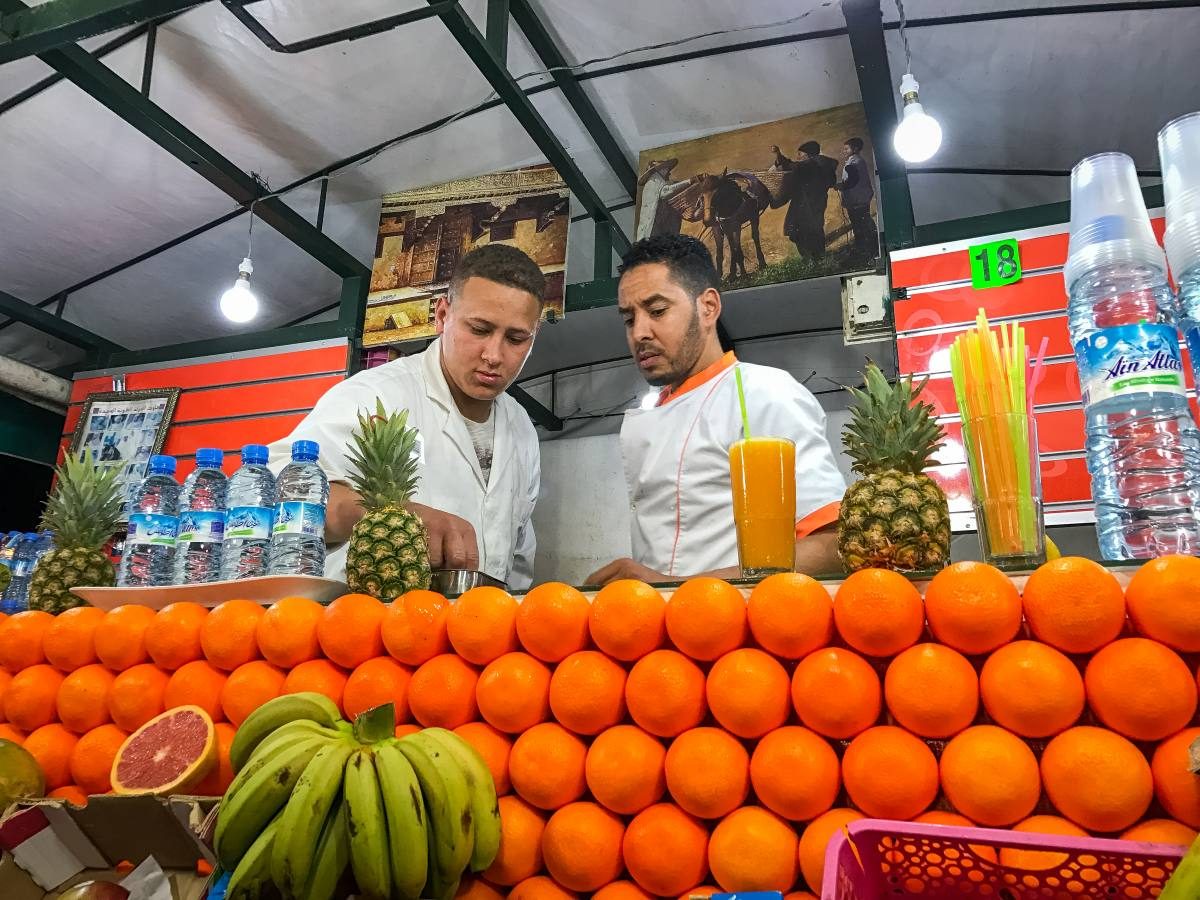 A bustling juice stall in the heart of Marrakech market, where you meed many Marrakech travel tips to survive. 
