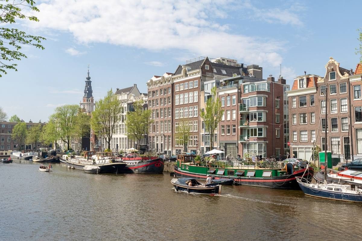 Canal with traditional Dutch building in the de Pijp Amsterdam neighborhood, a great choice for where to stay in Amsterdam