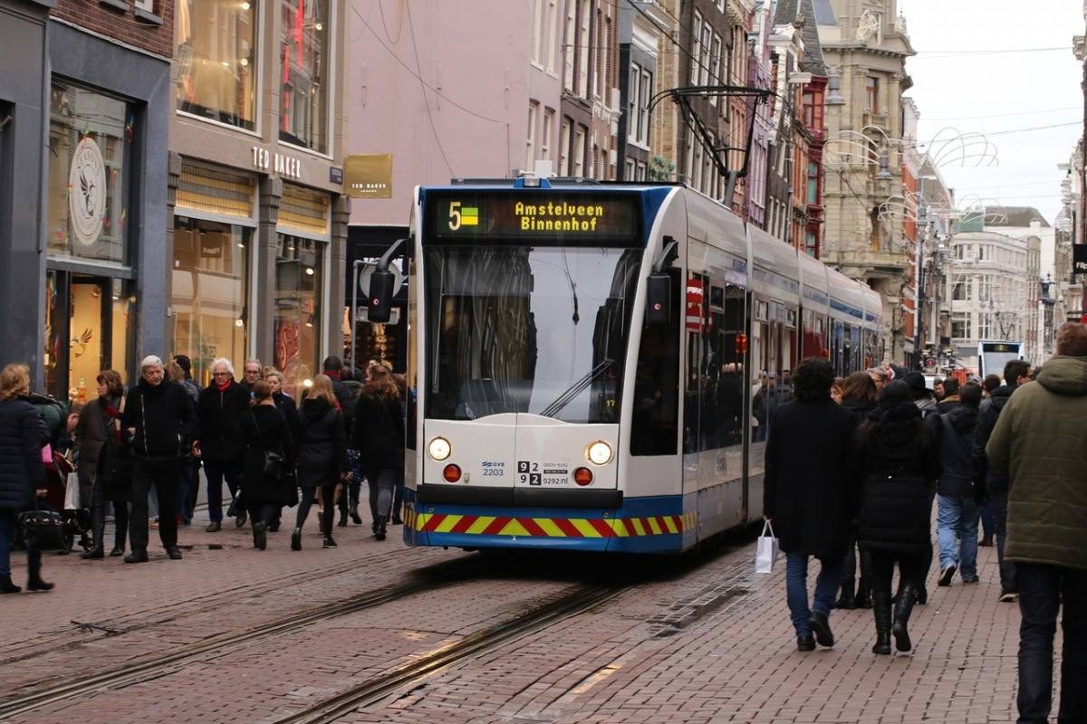 Tram number 5 to Amstelveen Binnenhof making its way through a bustling street in Amsterdam, typical public transport for those staying in the city.