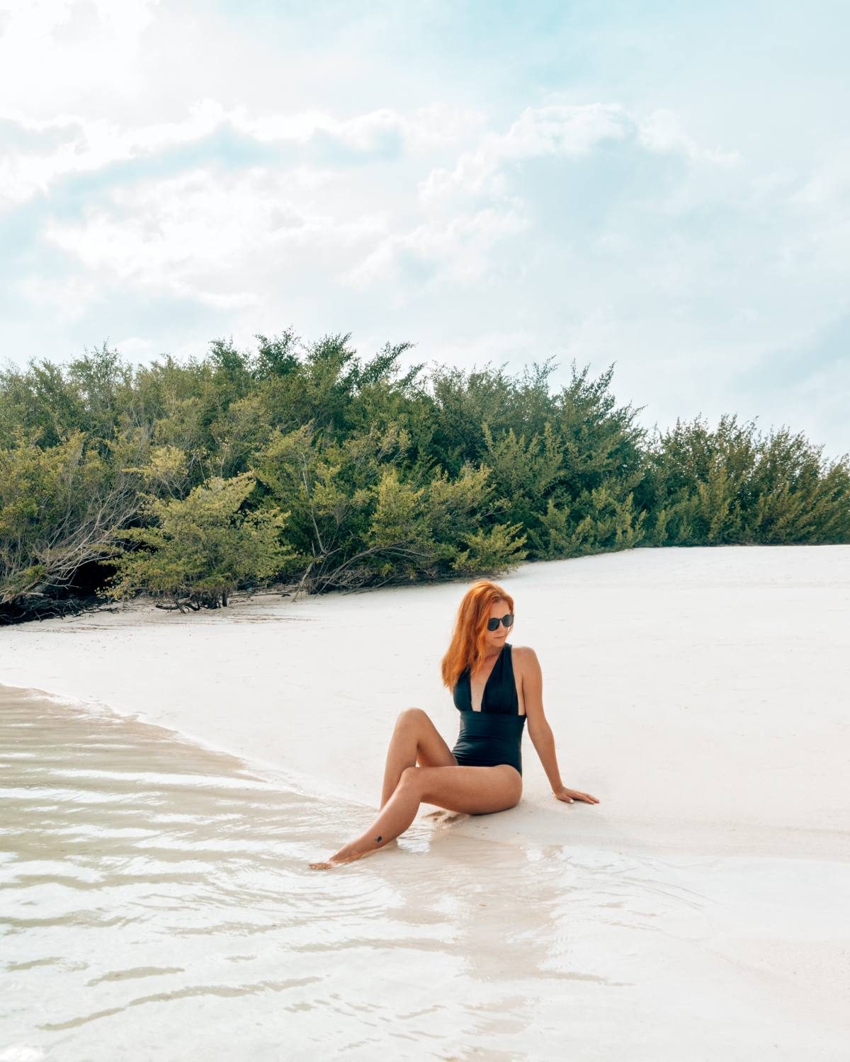 Lady wearing a black plunge bikini from Summersalt.