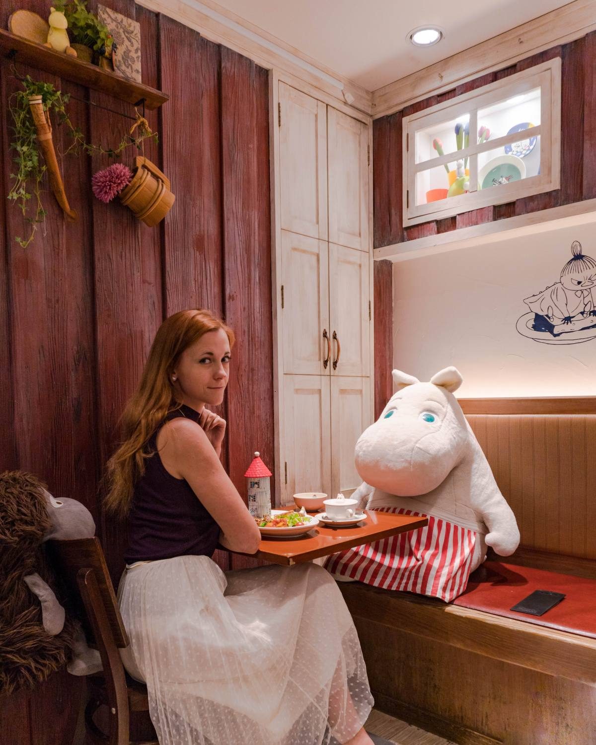 Dining with a whimsical stuffed character in a themed Moomin Cafe Japan