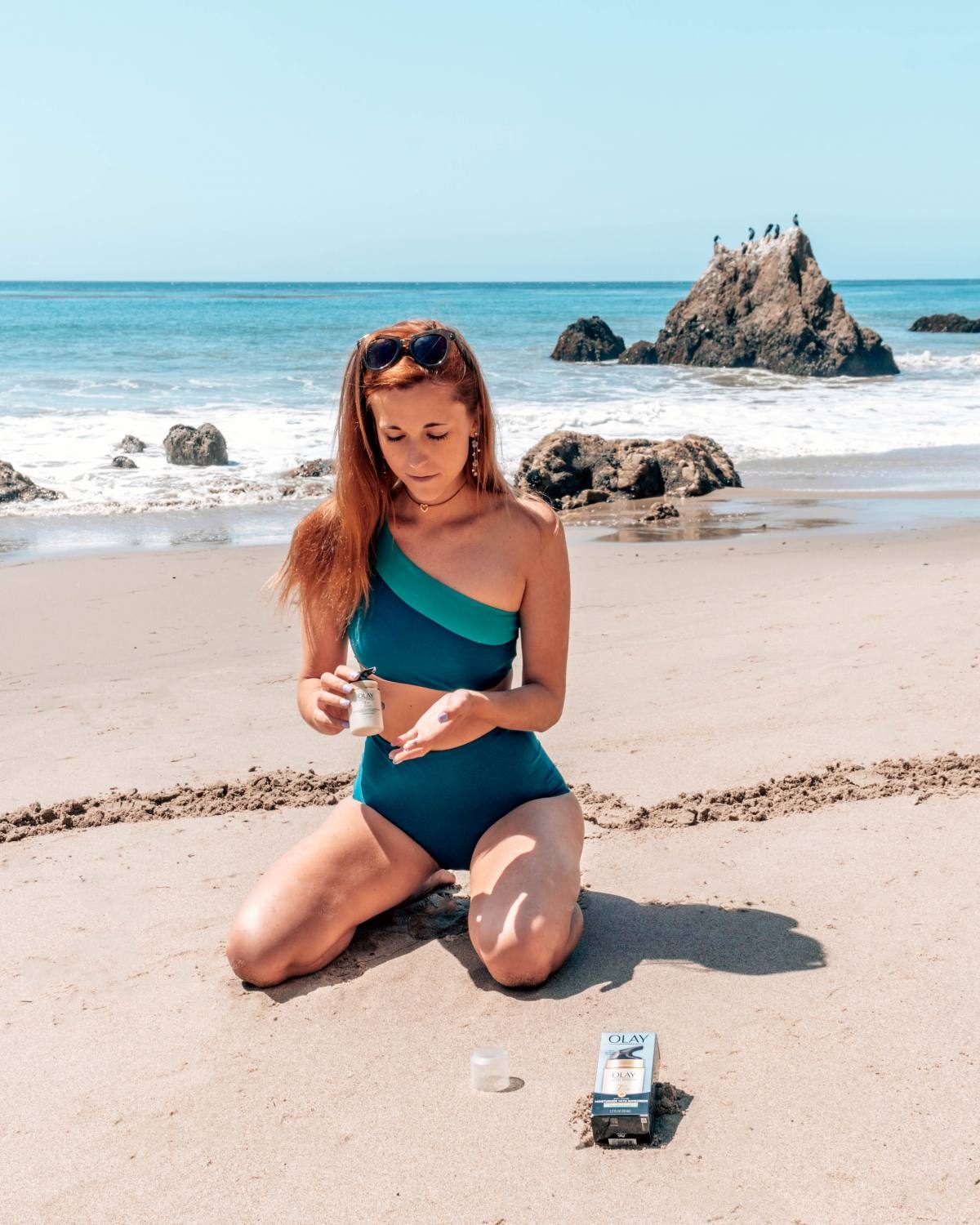 Lady wearing a one-shoulder blue bikini from Summersalt.