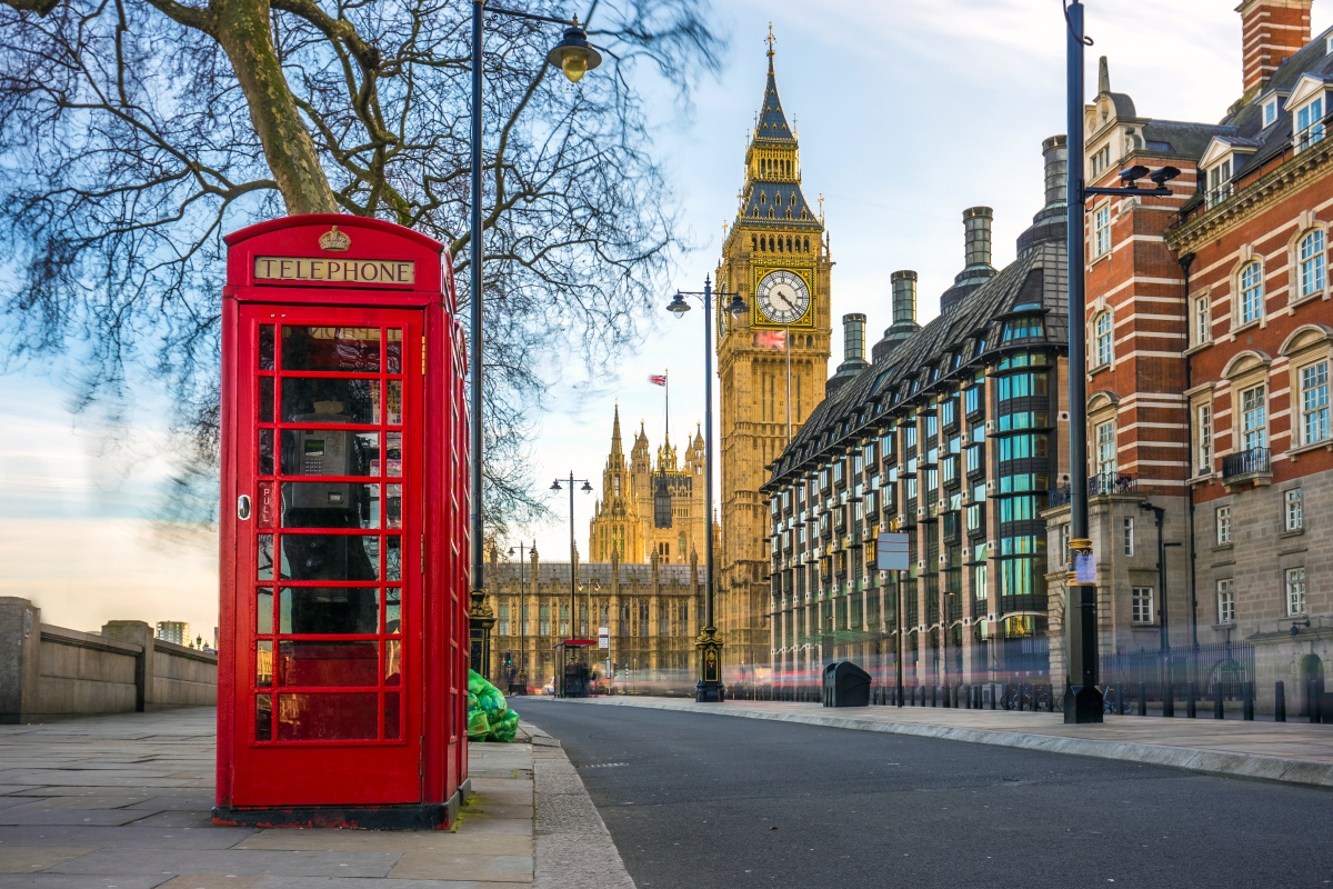 Classic red telephone box with the iconic Big Ben and the Houses of Parliament in the background, capturing the quintessential symbols of London, a top tip for tourists seeking the perfect photo opportunity.