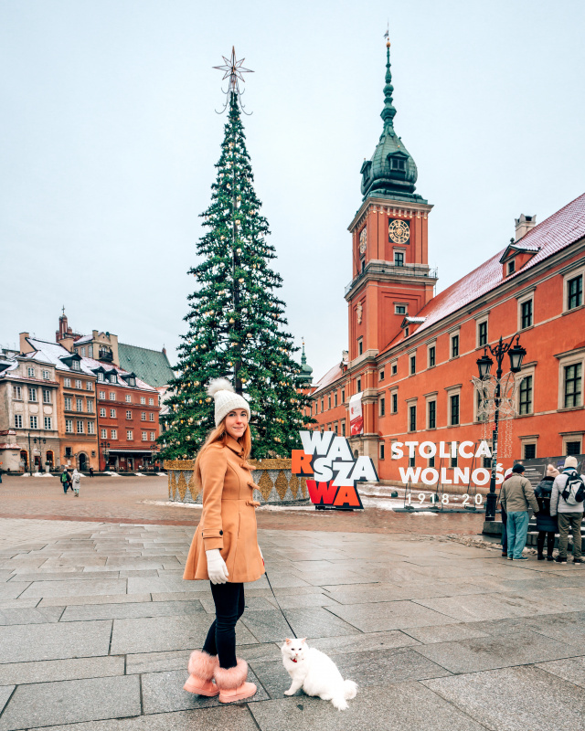 Lady in Warsaw Old Town wearing a maternity coat.