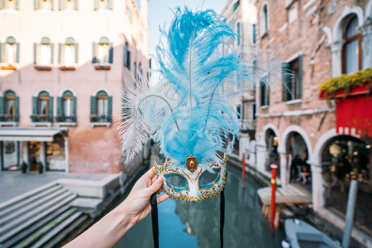 Hand-held traditional Venetian mask, a classic souvenir showcasing the cultural artistry of Italy.
