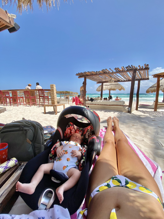 Peaceful baby nap in a stroller by the beach, while mom enjoys the serene Mexican coastline.
