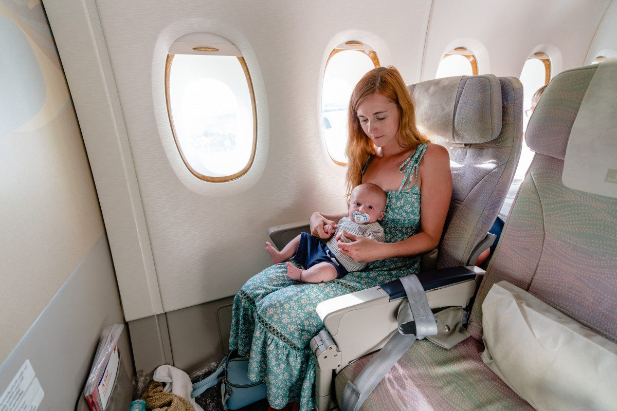 Mother soothing her baby on an airplane, an example of the experience when flying with a baby.
