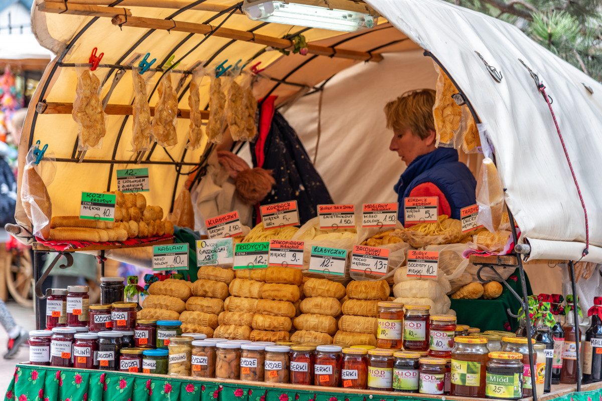 A traditional Polish market stall brimming with local cheeses and goods, inviting visitors to taste the flavors of Poland.
