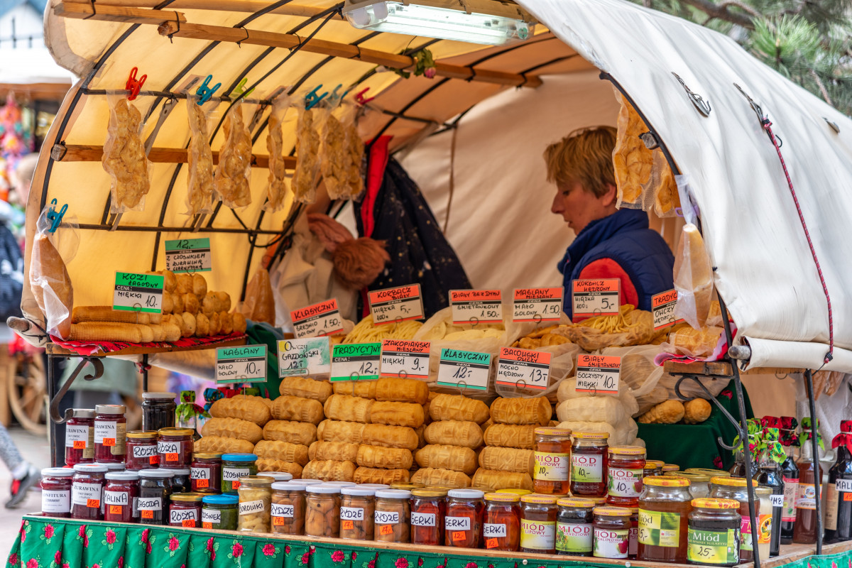 Vibrant Polish farmers' market scene with various traditional foods, including Oscypek & Bryndza cheeses and fresh jams, reflecting Poland's rich agricultural produce.