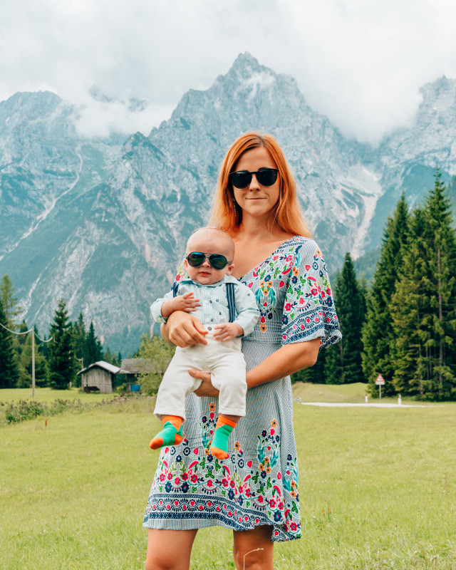 Mother and baby posing in front of majestic Italian Alps, showcasing family-friendly travel destinations in Italy.
