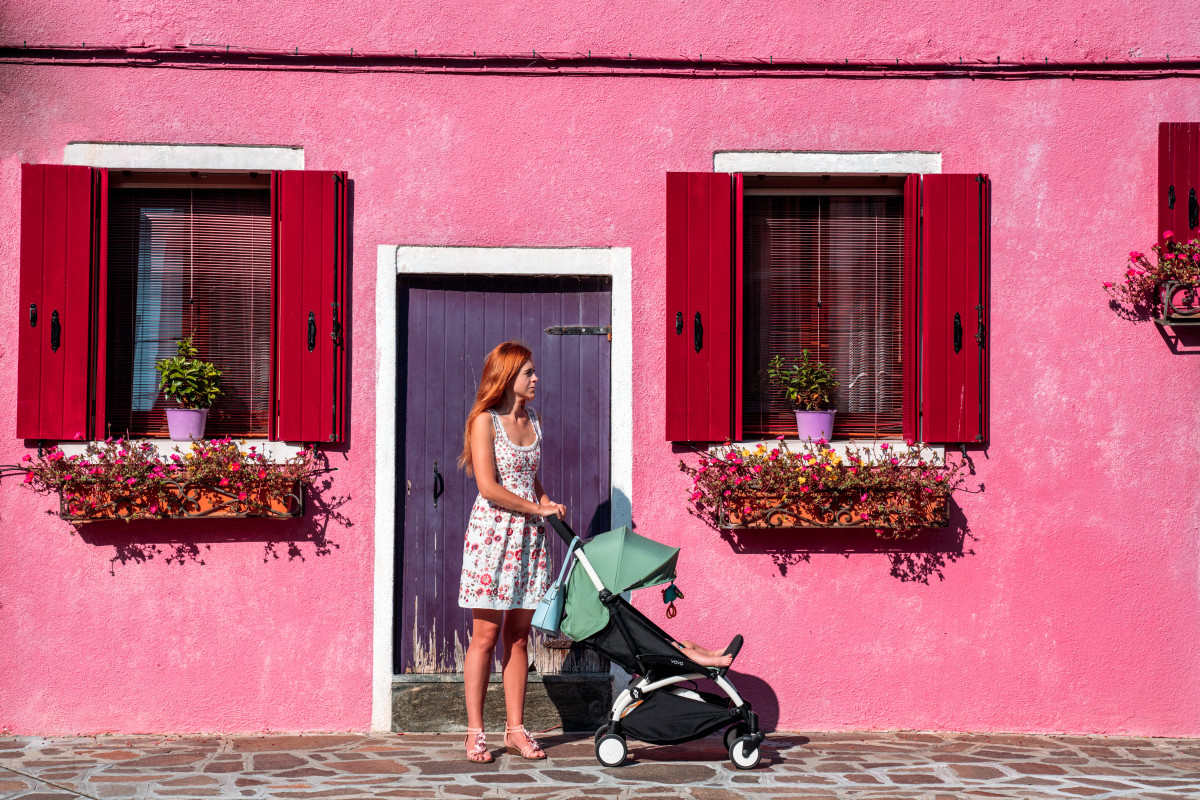 Mom pushing her baby in a travel stroller in Italy