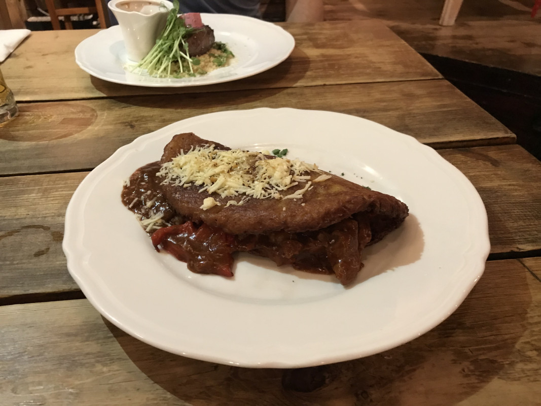 Traditional Polish Zapiekanka on plate, a popular street food in Poland, featuring open-faced toasted baguette with toppings and cheese.