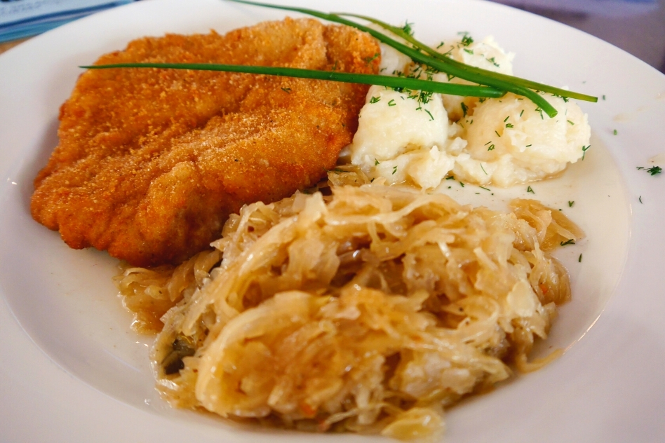 Classic Polish Schnitzel served with mashed potatoes and sauerkraut, a testament to Poland's rich tradition in comfort food.