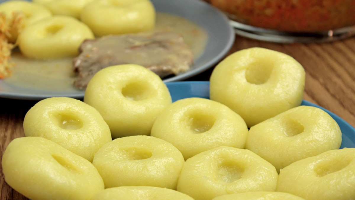 Polish potato dumplings, called slaskie, a beloved traditional food in Poland, often filled with meat and served with crispy bacon bits.