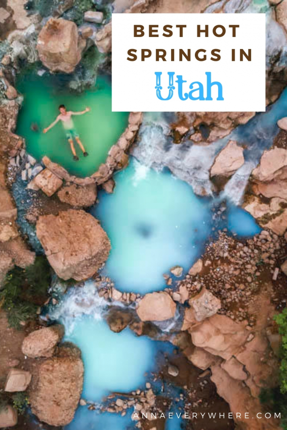 Aerial view of a person floating in a clear blue hot spring surrounded by rocks, one of the best hot springs in Utah.
