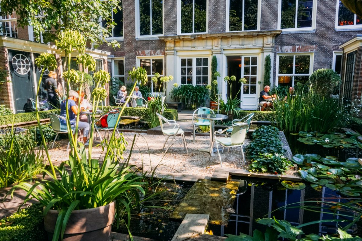 Tranquil garden seating outside a historic Amsterdam building, a peaceful retreat within your 2 days in Amsterdam visit.