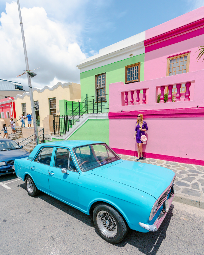 Colorful houses in Bo-Kaap, Cape Town, with a vintage turquoise car parked in front, showcasing the vibrant cultural heritage and picturesque streets that await visitors in the city.