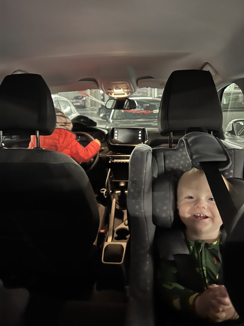 Baby smiling in the car in a European travel car seat 