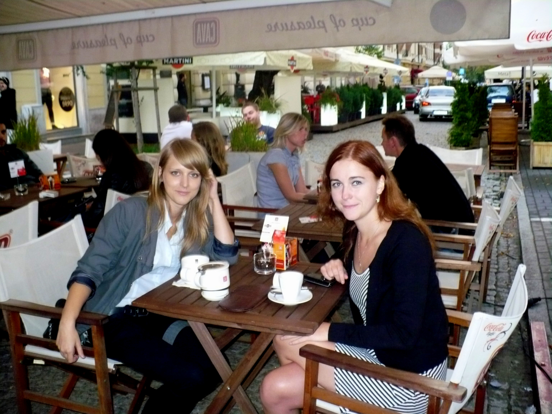 Two friends enjoying coffee at an outdoor cafe in Warsaw, a casual slice of daily life living in Poland.
