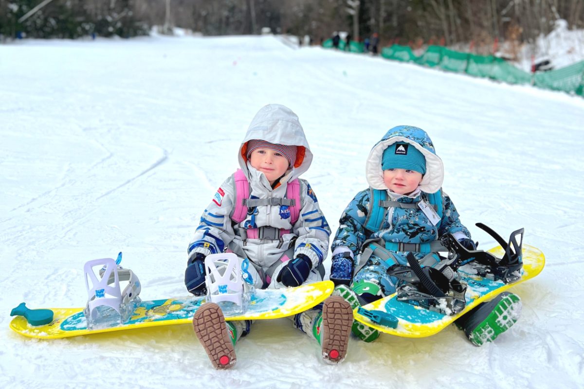 Toddlers snowboarding