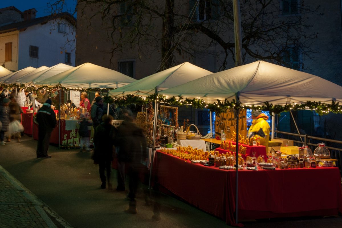 Bustling evening Christmas market in Italy, a go-to place for festive Italy souvenirs.
