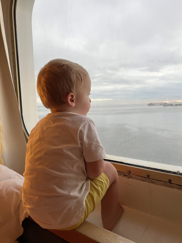 Baby on a cruise looking through the window.