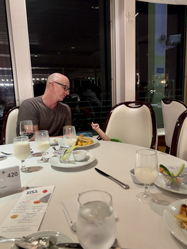 Father and child enjoying dinner time on a cruise,