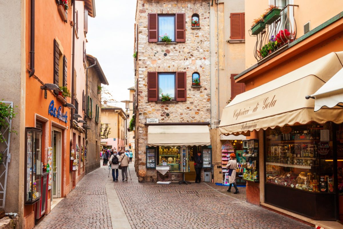 Cobblestone alley lined with quaint shops, ideal for buying unique Italy souvenirs.
