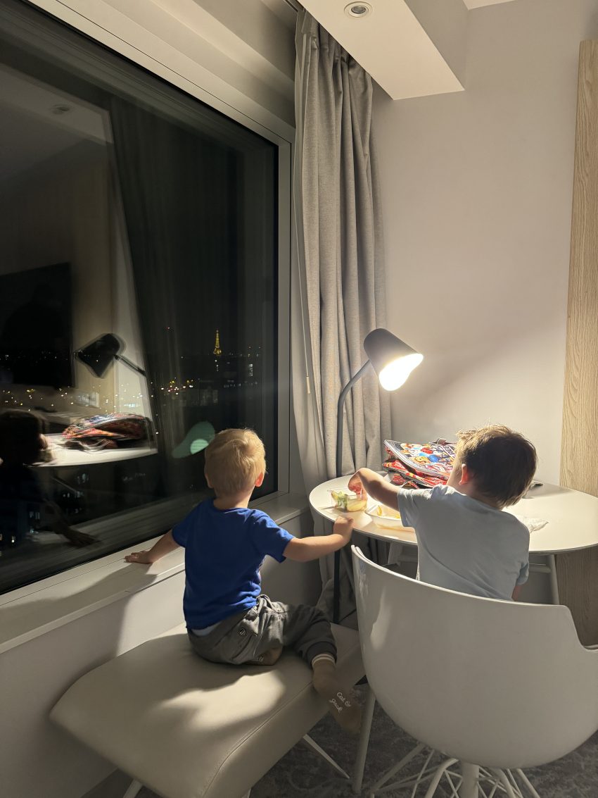 Kids watching Eiffel Tower sparkle from a hotel in Paris
